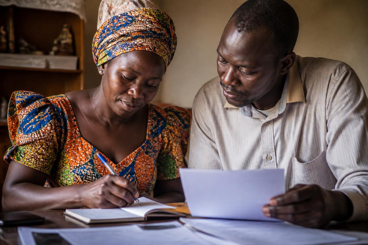 A Ugandan couple going through their household paperwork together at home